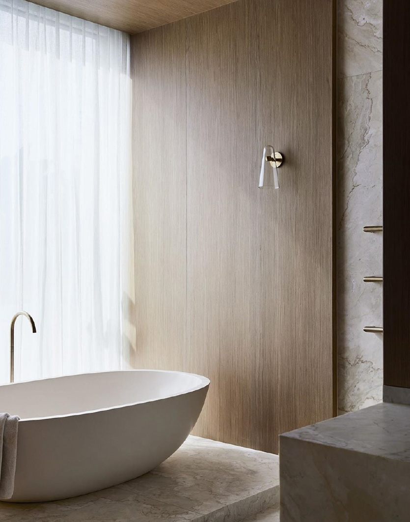 a photo of apaiser stone freestanding bath sitting on a plinth in an elegant bathroom